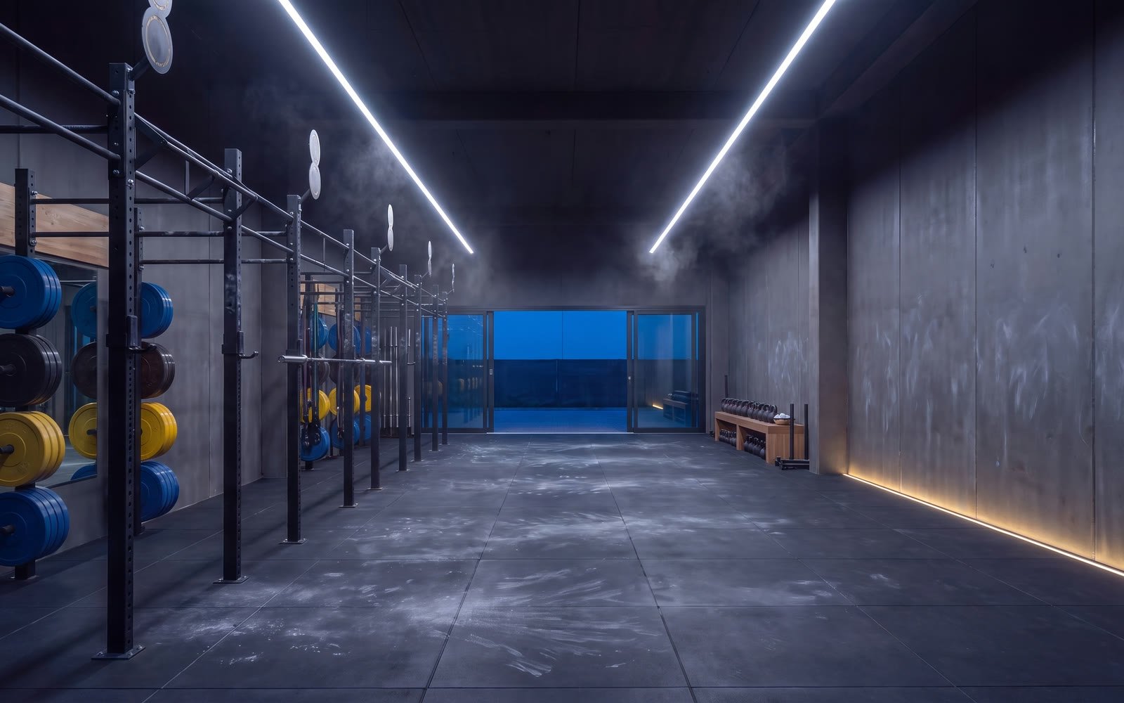 Die leere Trainingsfläche von KLAR im kühlen Hallenlicht, Rig und Kettlebells, kein Mensch